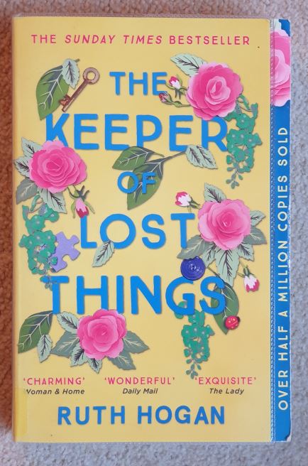 Book cover showing a loose wreath of flowers with key and button